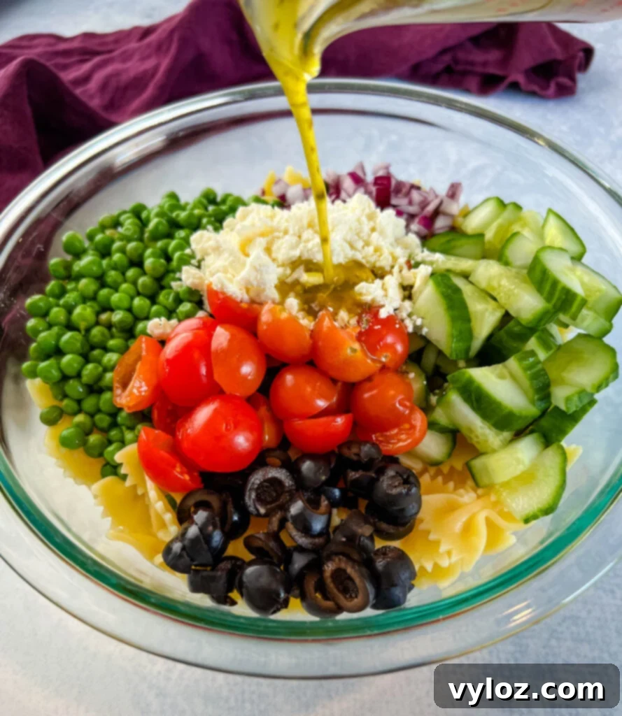 Zesty Bow Tie Pasta Salad 9 Italian dressing poured into bowl of bow tie pasta salad