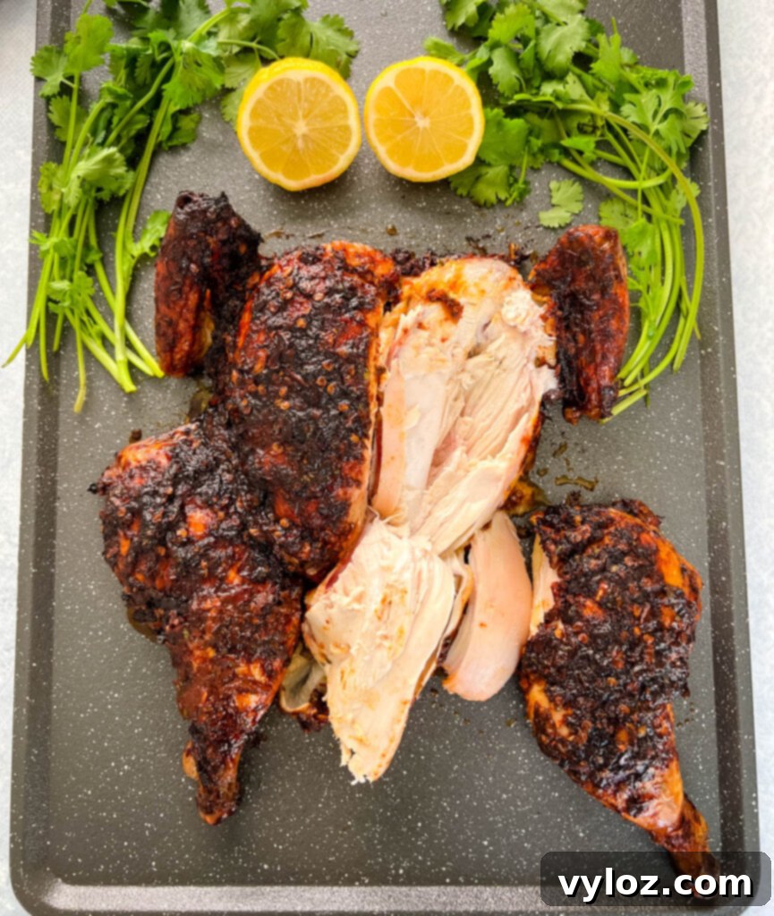 Ultimate Traeger Smoked Whole Chicken 13 sliced smoked whole chicken on a pan