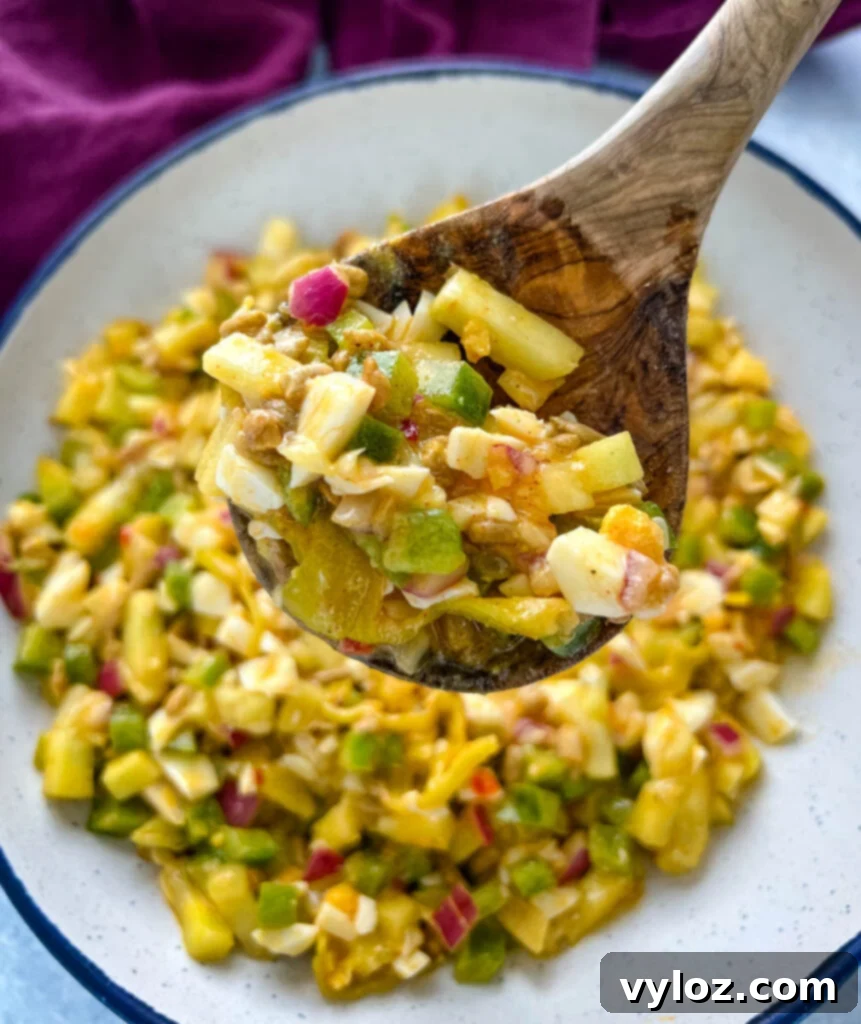 Your Go-To Hot Girl Summer Salad 8 The Hot Girl Summer Salad, a delightful and healthy choice, presented in a white bowl with a wooden spoon, showcasing its appealing mix of ingredients.