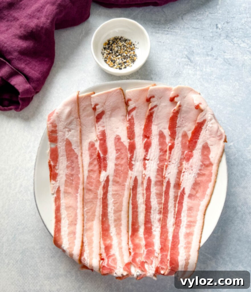 uncooked bacon on a plate with Everything But the Bagel Seasoning