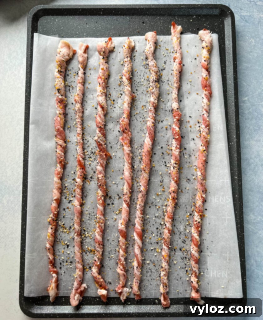 twisted bacon on a sheet pan seasoned with Everything But the Bagel Seasoning