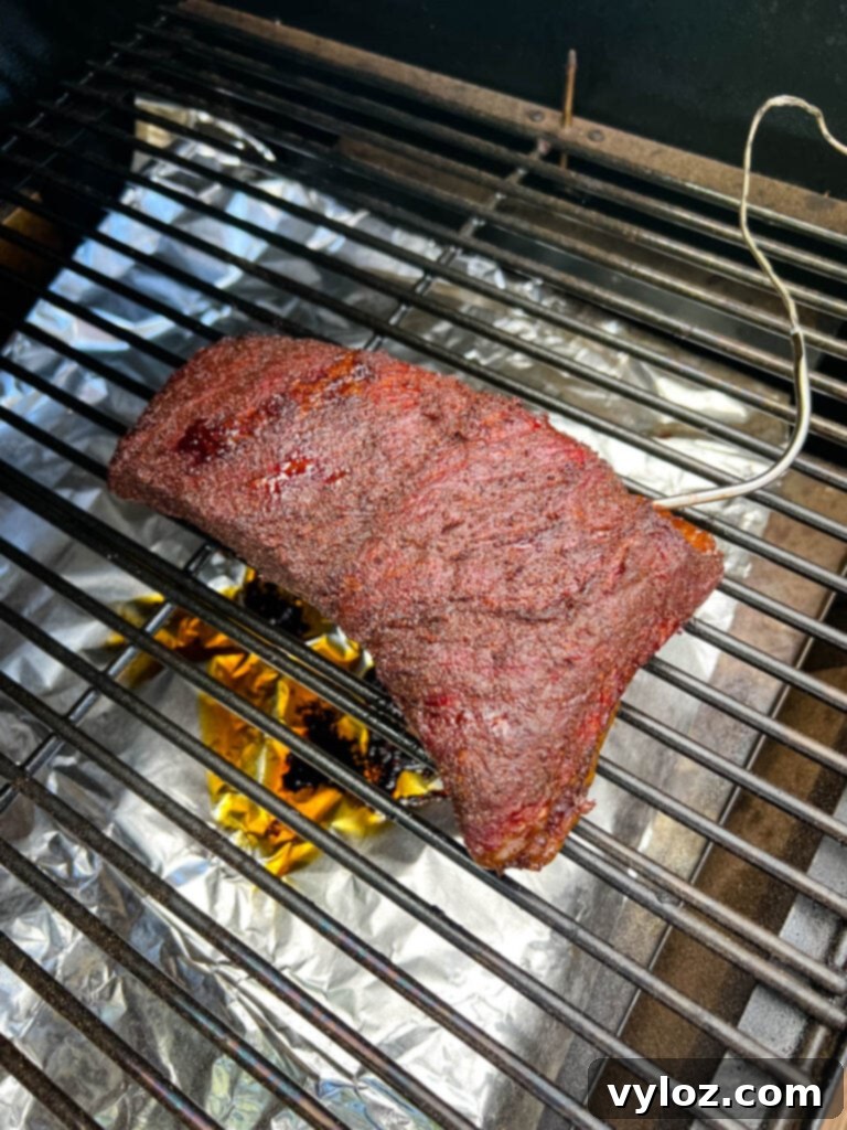 Smoked brisket on a Traeger pellet grill, showing the beautiful bark and smoke.