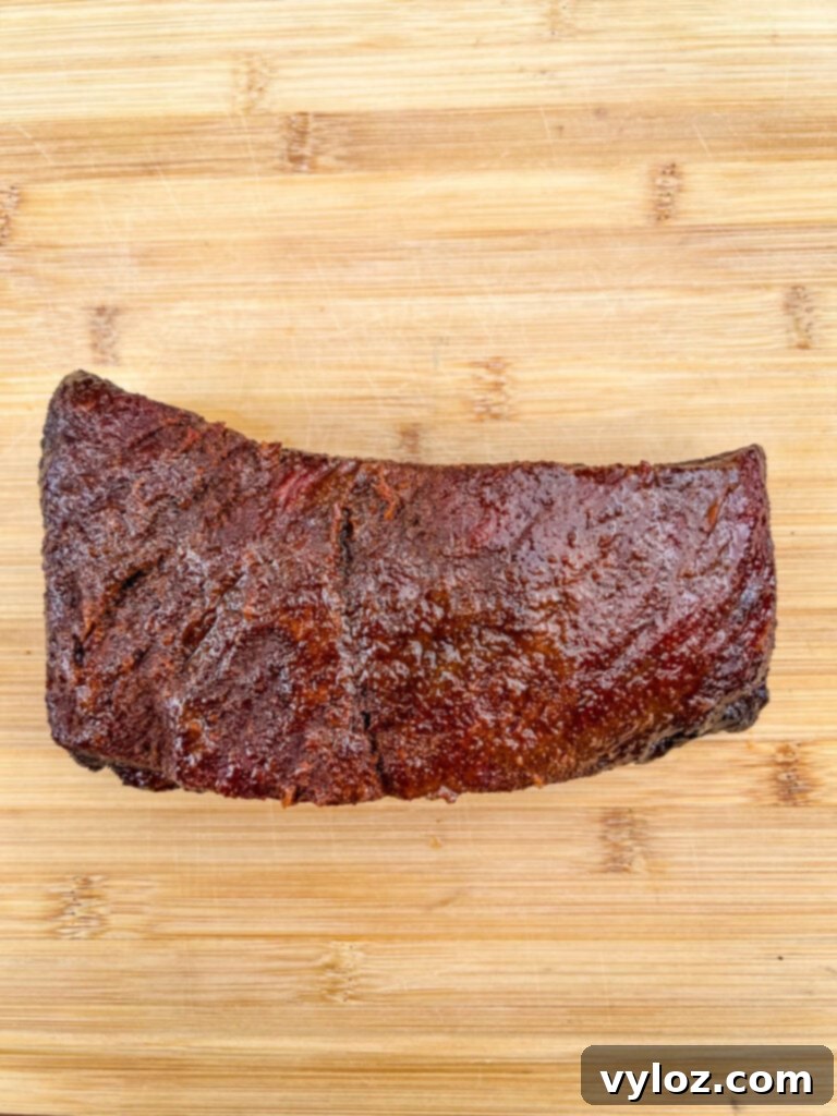 Traeger smoked brisket on a bamboo cutting board, showcasing its tender texture and readiness for carving.