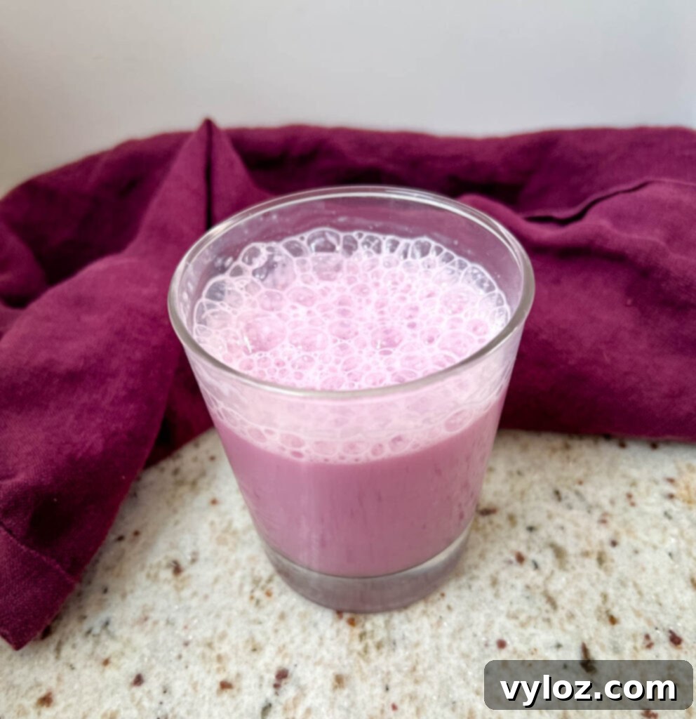 A glass cup filled with light pink Angel Milk, garnished with a tiny heart, showing the viral TikTok recipe in an inviting presentation.