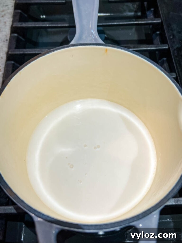 Milk gently warming in a saucepan, a key step for cozy Angel Milk.