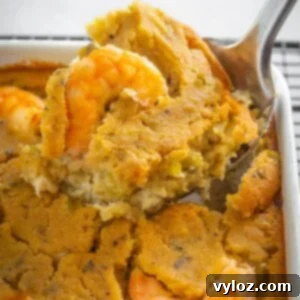 The Ultimate Seafood Dressing 11 A large spoonful of seafood cornbread dressing with crab and shrimp, showing a perfect serving.