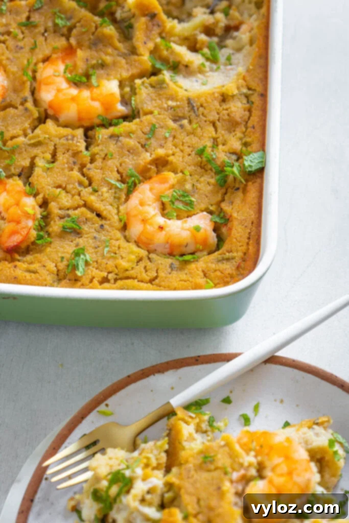 The Ultimate Seafood Dressing 12 A generous portion of seafood cornbread dressing, rich with shrimp and crab, served in a baking dish, highlighting its comforting appeal.