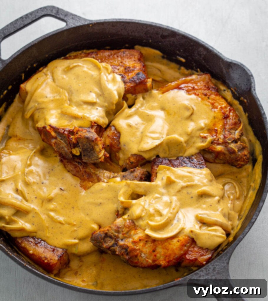 Soulful Southern Smothered Pork Chops 12 southern smothered pork chops in a cast iron skillet with gravy