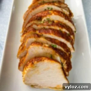 Slices of juicy slow cooker boneless turkey breast on a white plate, ready to be enjoyed