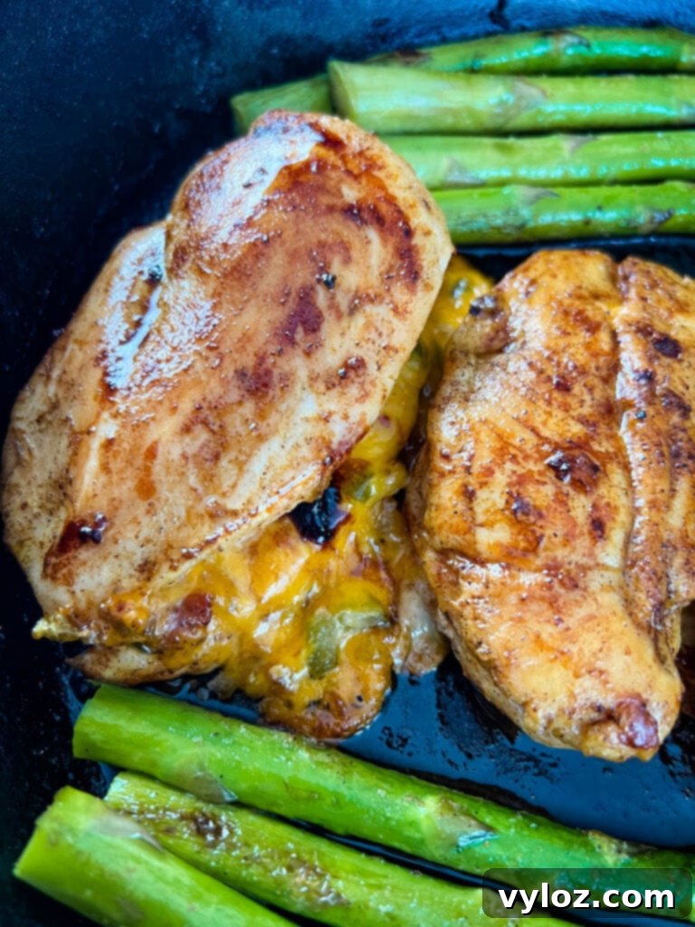 Perfectly Baked Stuffed Chicken 12 oven stuffed chicken breast in a cast iron skillet with asparagus