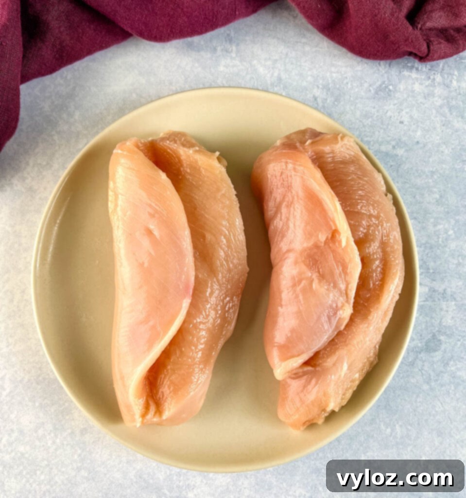 Perfectly Baked Stuffed Chicken 5 raw sliced chicken breasts on a plate