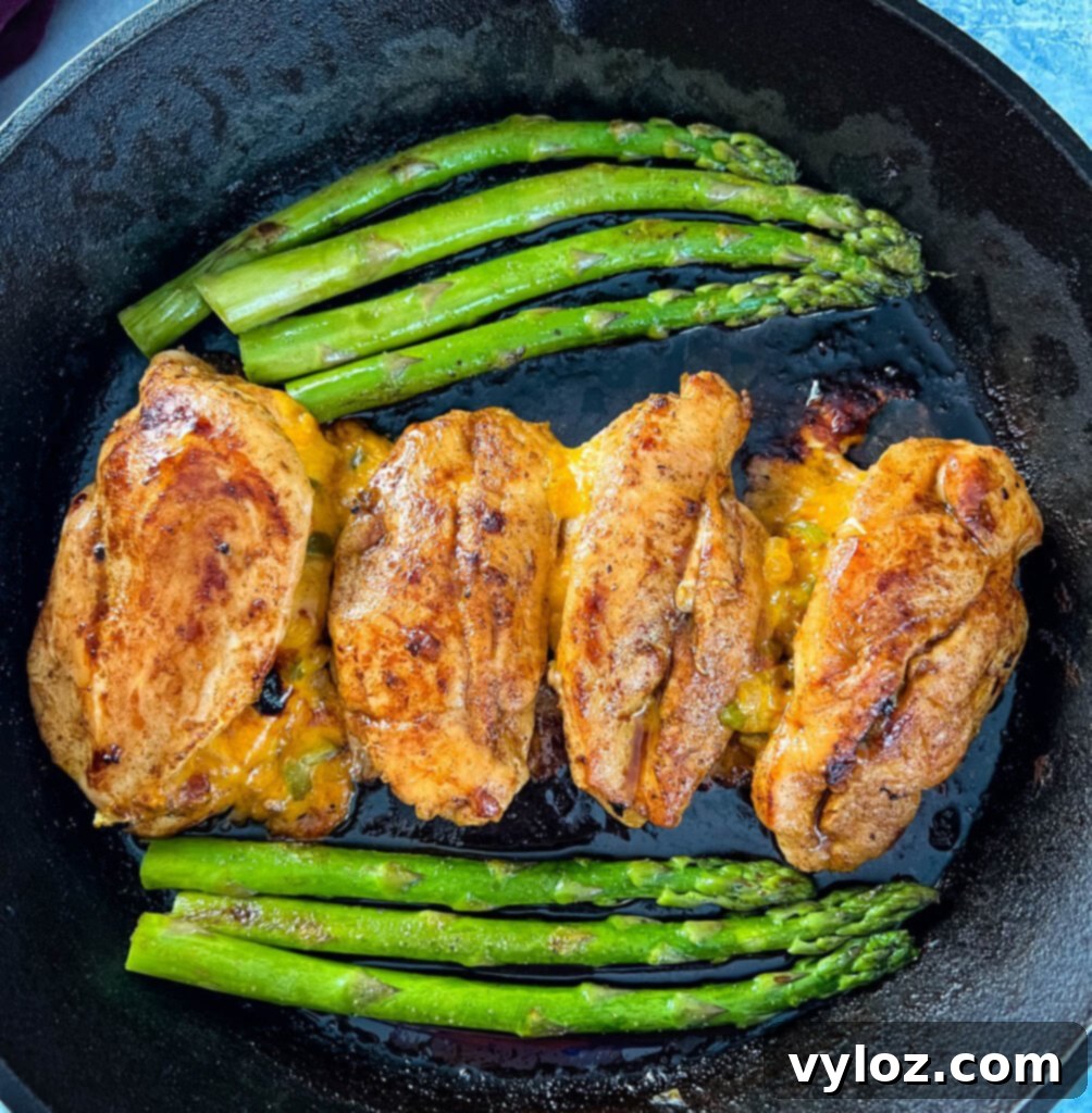Perfectly Baked Stuffed Chicken 10 oven stuffed chicken breast in a cast iron skillet with asparagus