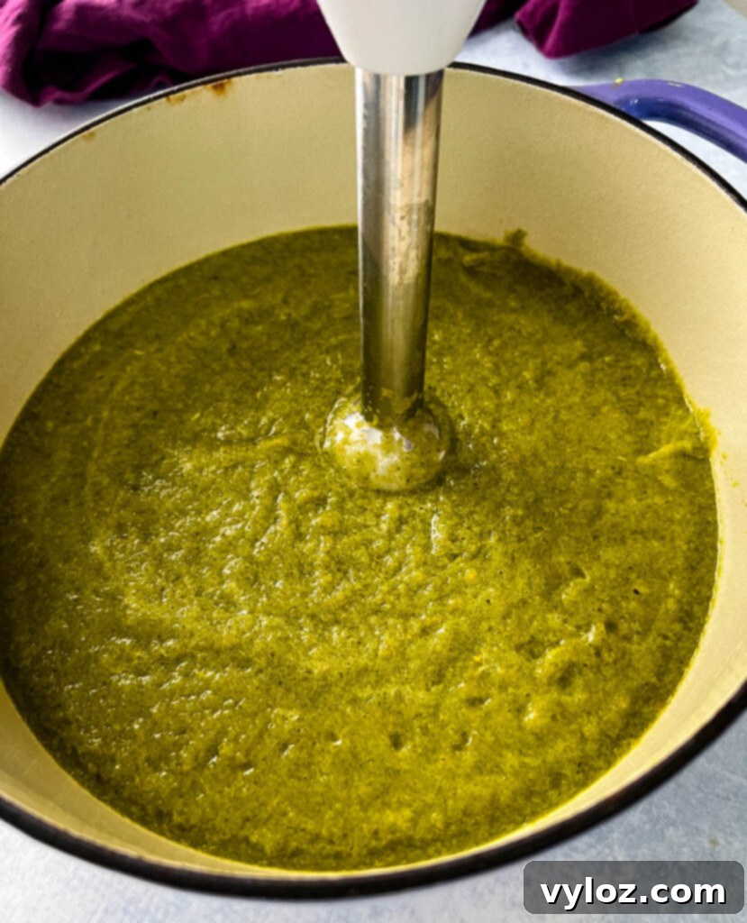 roasted poblano soup in a Dutch oven with an immersion blender