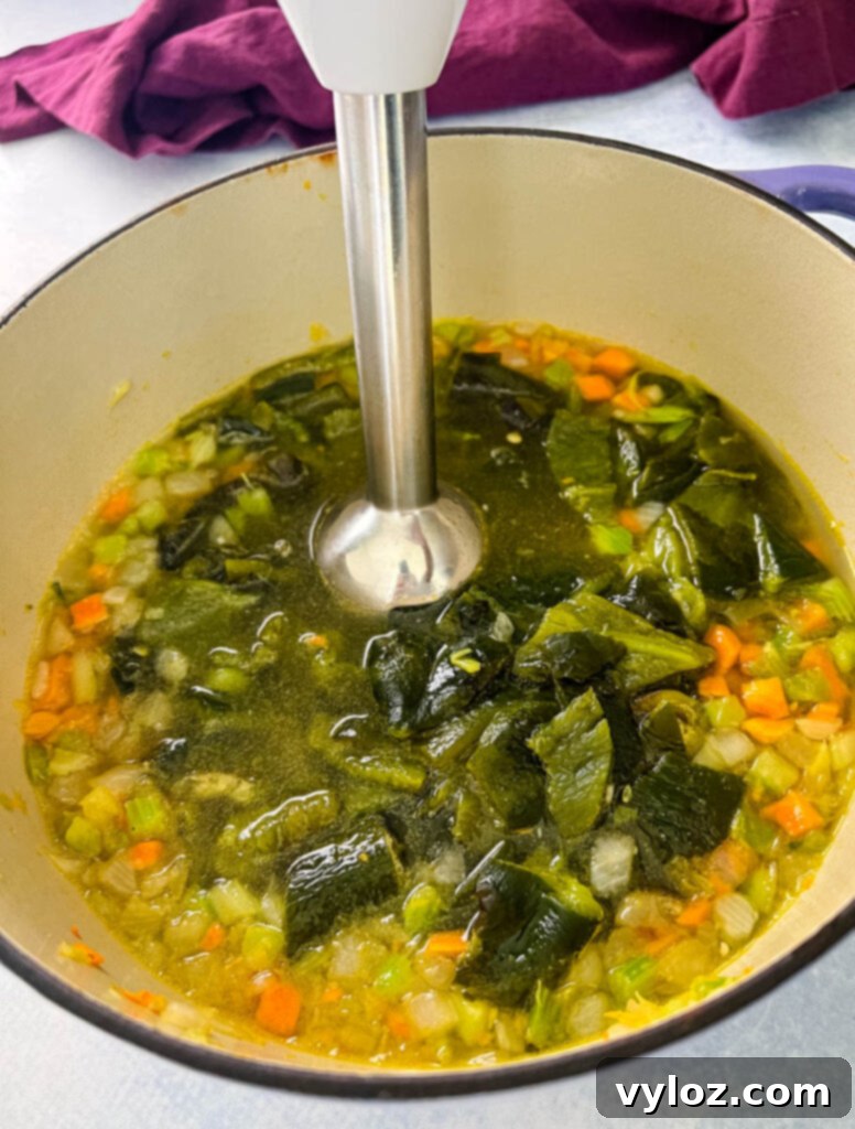 roasted poblano soup in a Dutch oven with an immersion blender
