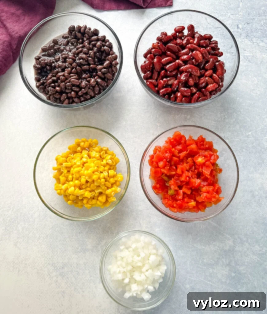 Hearty Slow Cooker Shredded Chicken Taco Soup 3 corn, beans, onion, tomatoes, and garlic in separate bowls