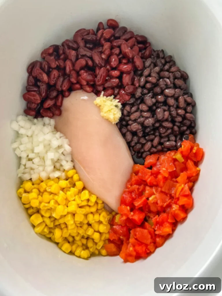 Hearty Slow Cooker Shredded Chicken Taco Soup 5 chicken breasts, beans, onion, tomatoes, and garlic in a slow cooker Crockpot