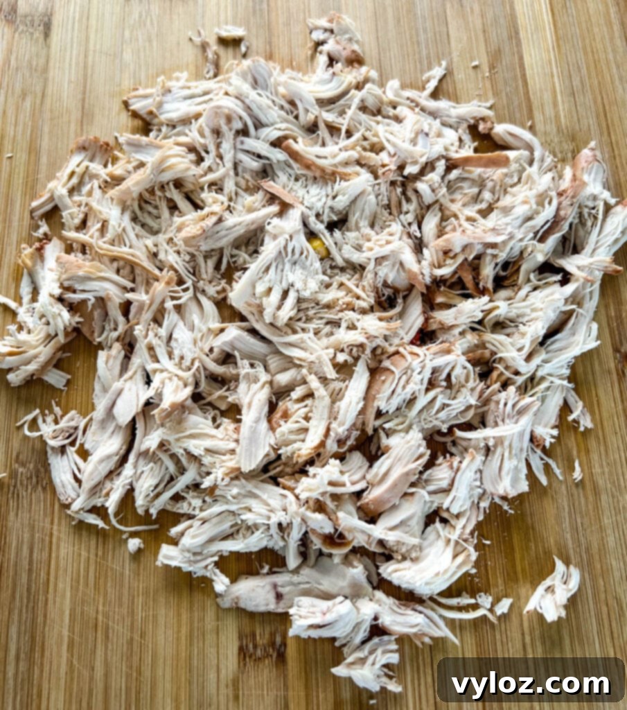 Hearty Slow Cooker Shredded Chicken Taco Soup 7 shredded chicken on a cutting board