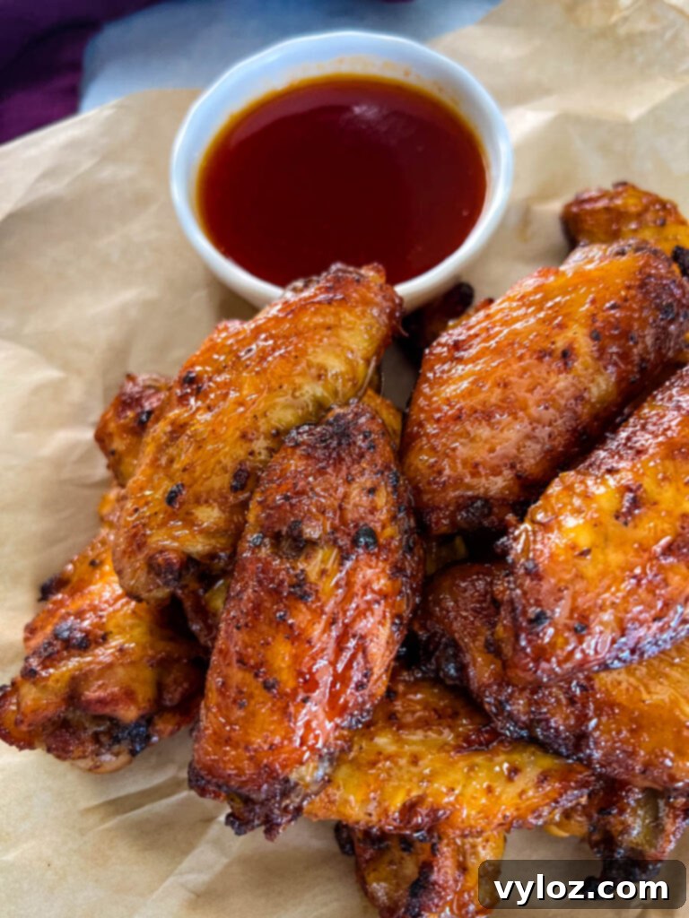 Fiery Honey Glazed Wings 13 honey hot wings on a plate with hot sauce