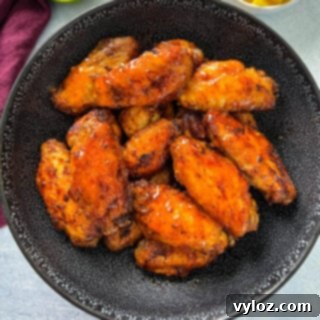 A black bowl brimming with sweet and spicy mango habanero wings.