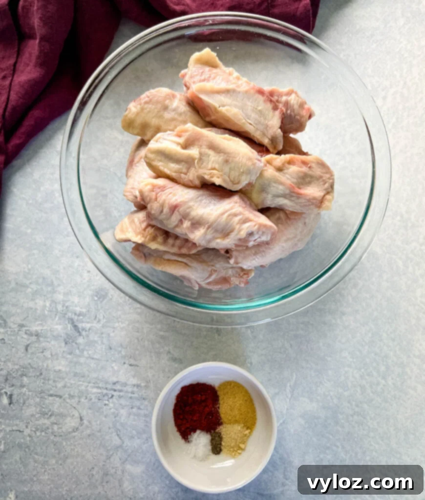 Raw chicken wings and bowls of spices, ready for seasoning.