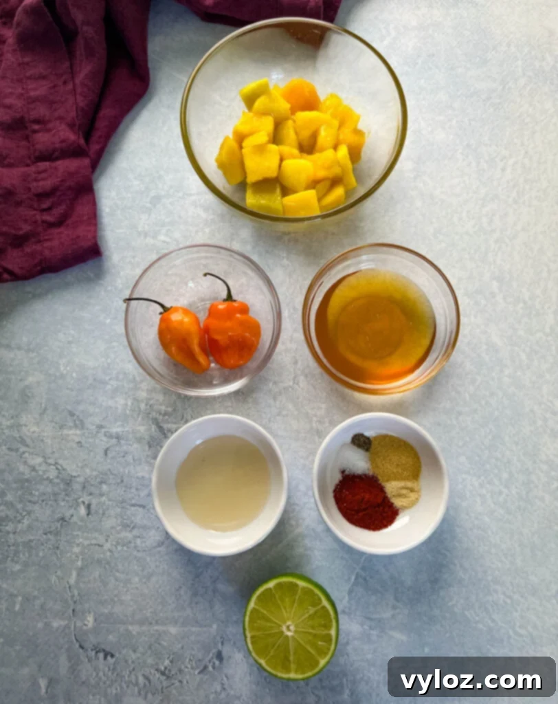 Individual bowls containing mangos, habaneros, honey, vinegar, and various spices.
