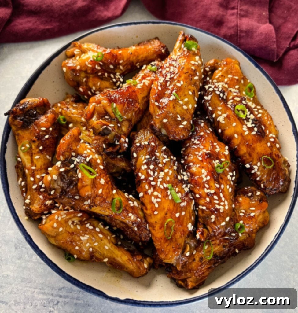 teriyaki chicken wings in a white and blue bowl with sesame seeds