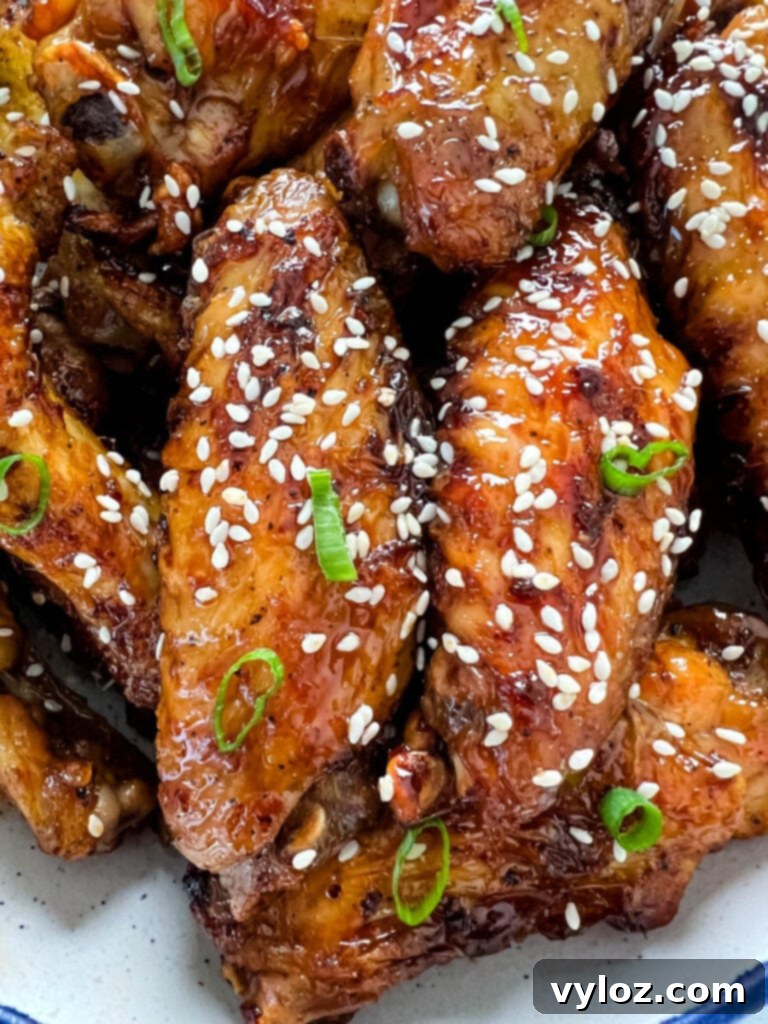 teriyaki chicken wings in a white and blue bowl with sesame seeds