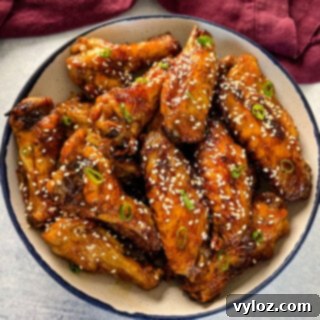 teriyaki chicken wings in a white and blue bowl with sesame seeds