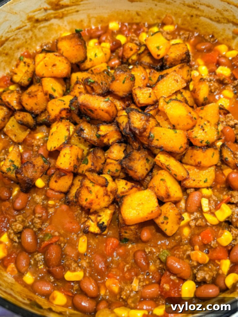 Hearty Butternut Squash Chili with Your Choice of Meat 9 Butternut squash chili bubbling gently in a large pot on the stovetop.