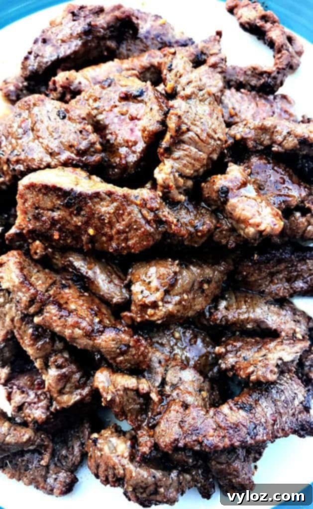 10-Minute Instant Pot Carne Asada Tacos 3 Grilled and thinly sliced sirloin steak for Instant Pot 10-Minute Steak Tacos (carne asada) on a white plate