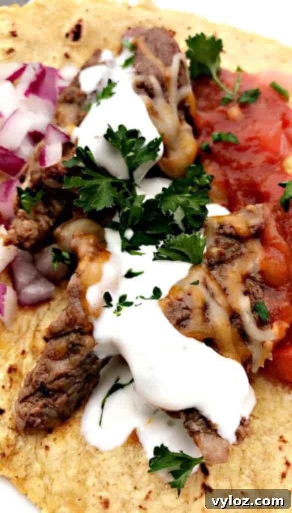 10-Minute Instant Pot Carne Asada Tacos 7 Instant Pot 10-Minute Steak Tacos (Carne Asada) topped with melted cheese and a dollop of sour cream