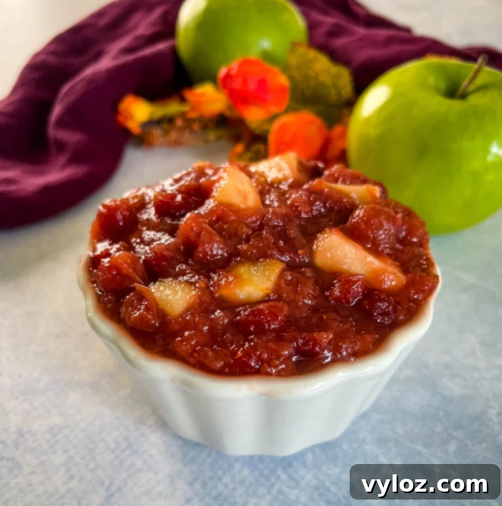 Apple Infused Cranberry Sauce 2 apple cranberry sauce in a white bowl with a fresh apple