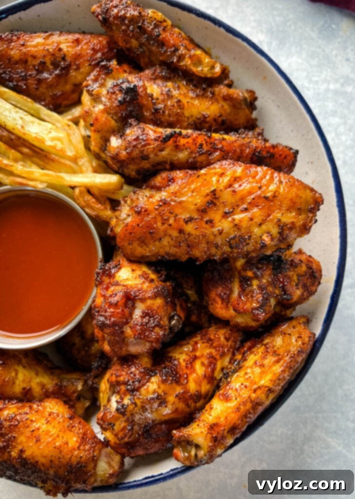 Cajun chicken wings in a bowl with french fries