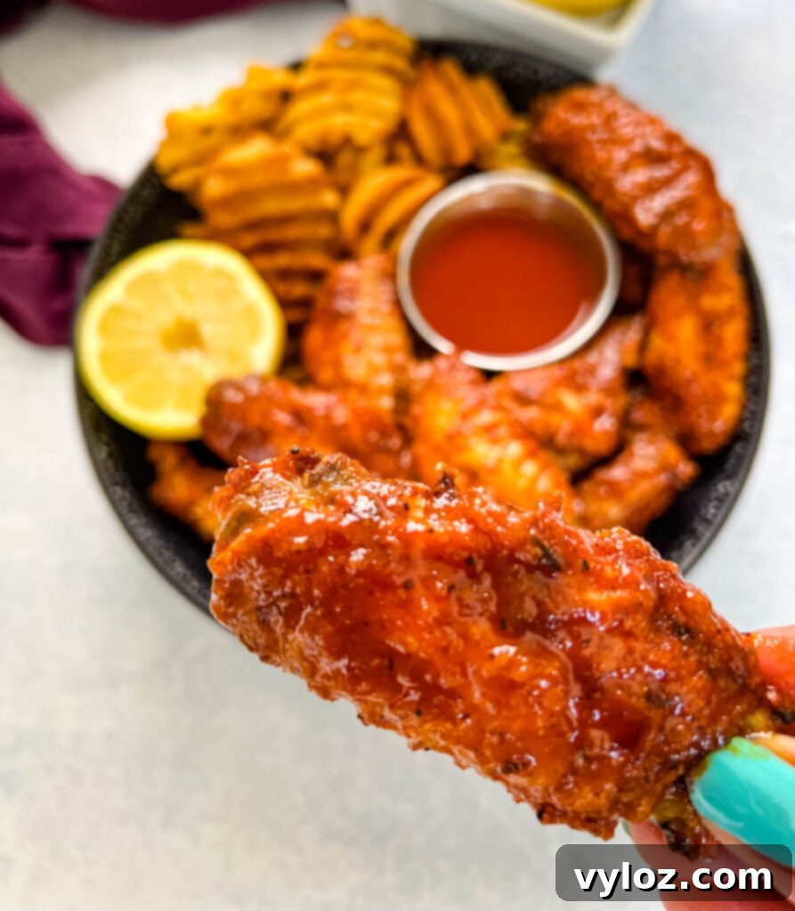 person holding hot lemon pepper chicken wing