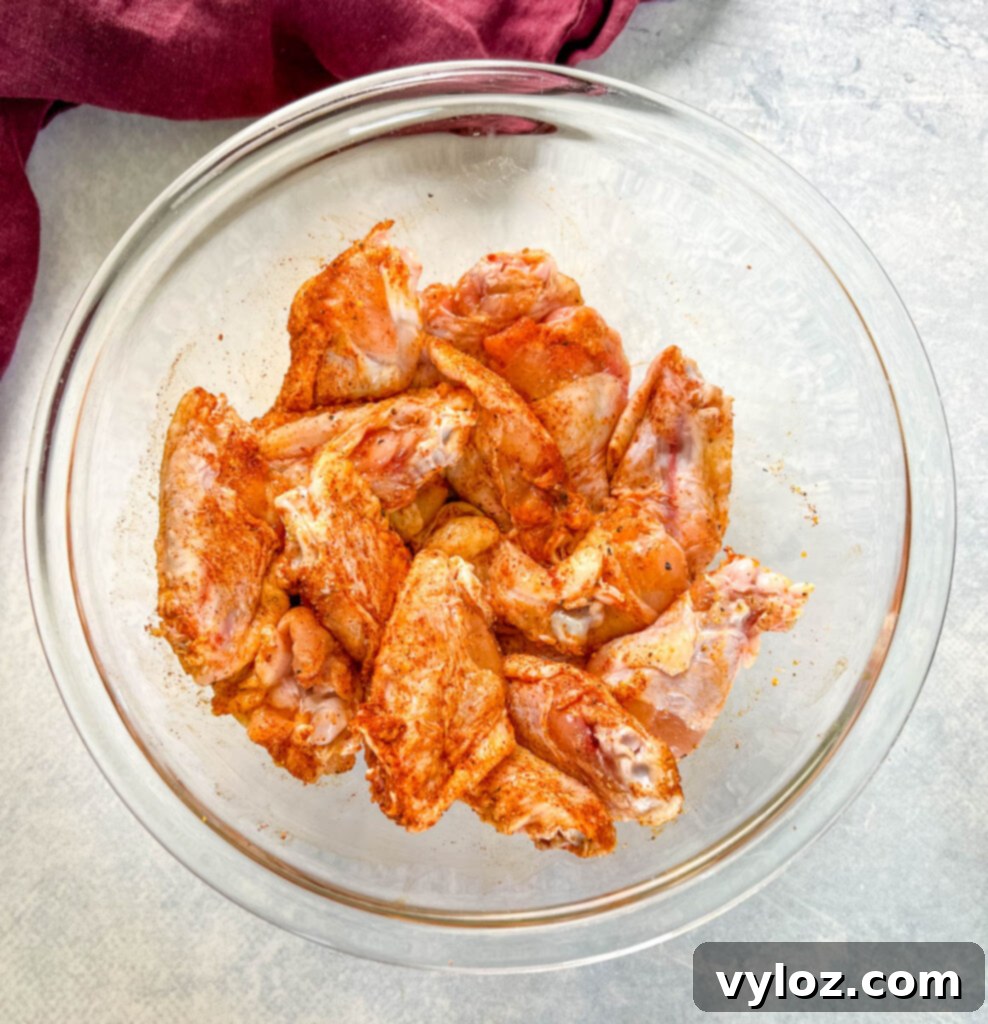 raw hot lemon pepper chicken wings seasoned in a glass bowl