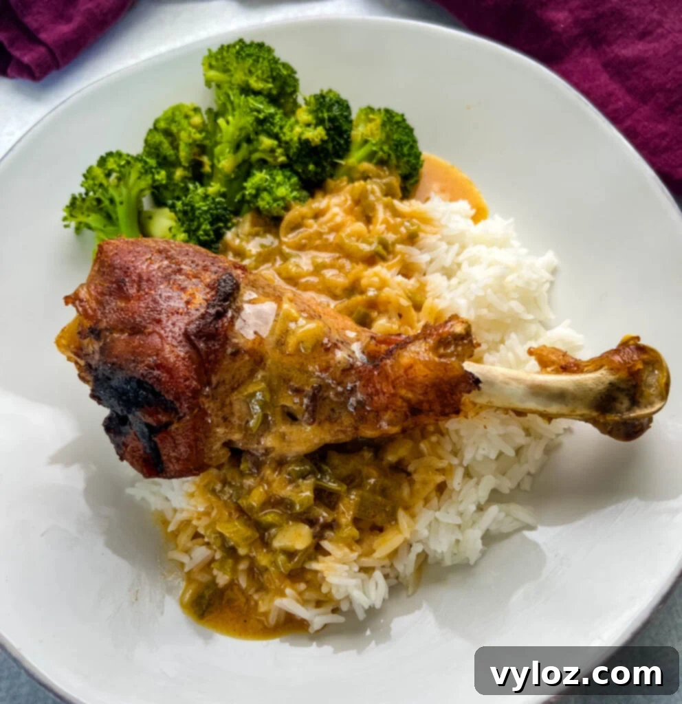 baked turkey leg on a plate with rice, gravy, and broccoli