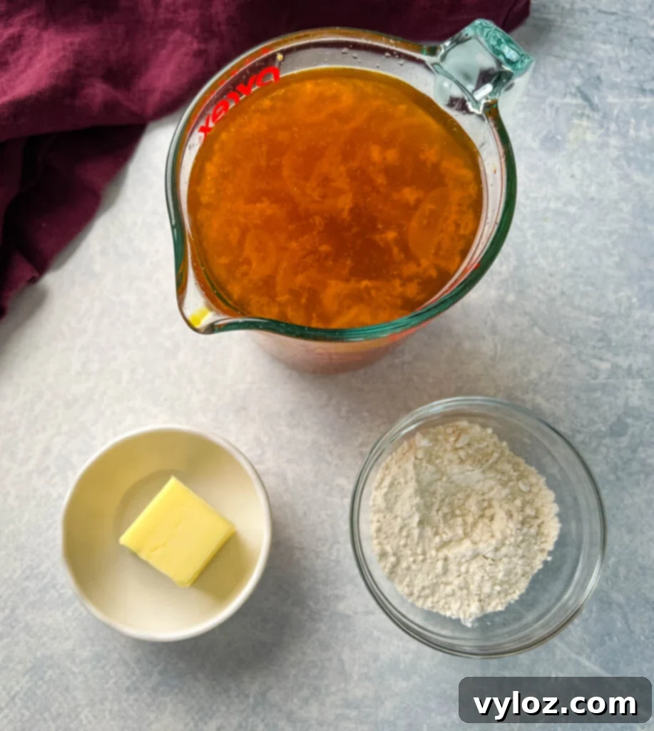 Separated bowls of turkey drippings, unsalted butter, and all-purpose flour, ready for gravy preparation
