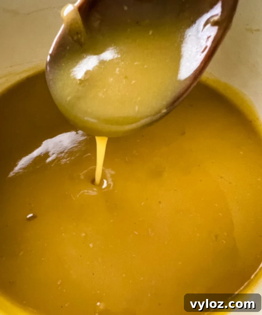 Rich turkey drippings gravy simmering in a saucepan on the stovetop