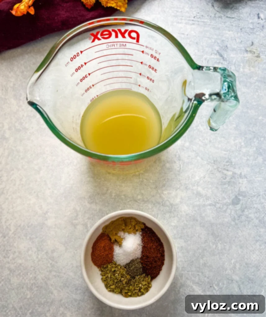 Hearty Ground Chicken Chili 6 Small glass bowls containing broth and various chili seasoning spices like chili powder, cumin, and oregano.