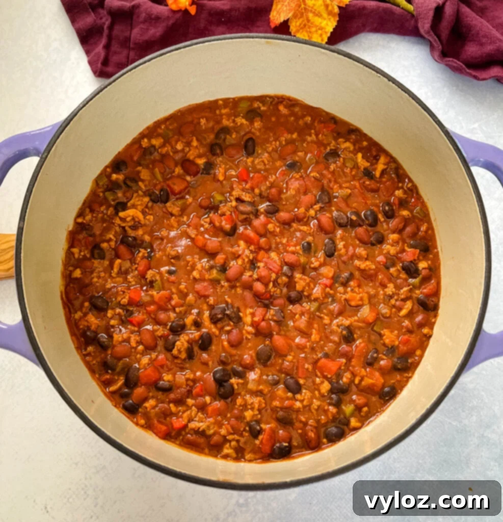 Hearty Ground Chicken Chili 10 Rich ground chicken chili simmering in a vibrant red Dutch oven, showcasing its hearty texture.