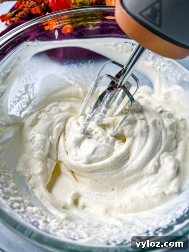 Zero Sugar Whipped Cream 6 Hand mixer whipping sugar free whipped cream in a glass bowl, showing the thickening process