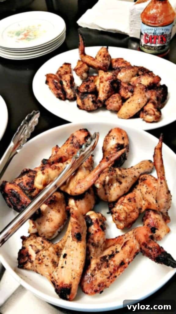 Grilled BBQ chicken wings in a large white bowl, close up