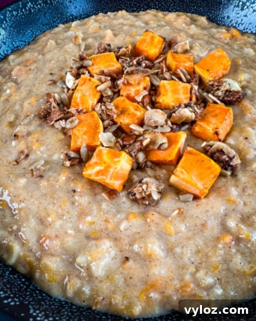 Sweet potato oatmeal in a black bowl topped with granola and honey, perfect for a cozy morning.