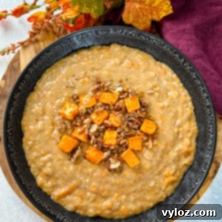 Sweet potato oatmeal in a black bowl topped with granola and honey