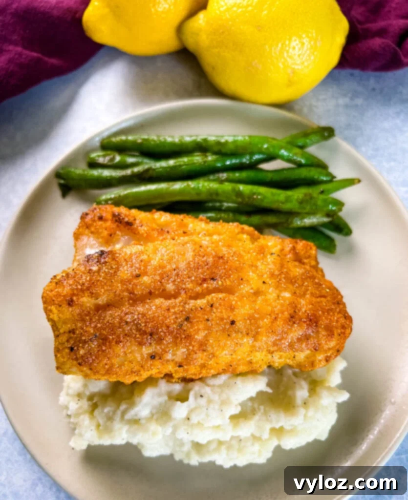 lemon pepper fish, mashed potatoes, and green beans on a plate