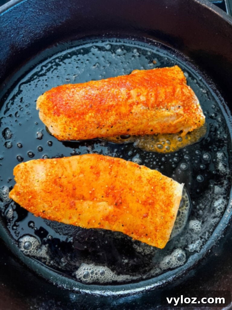 seasoned fish in a cast iron skillet