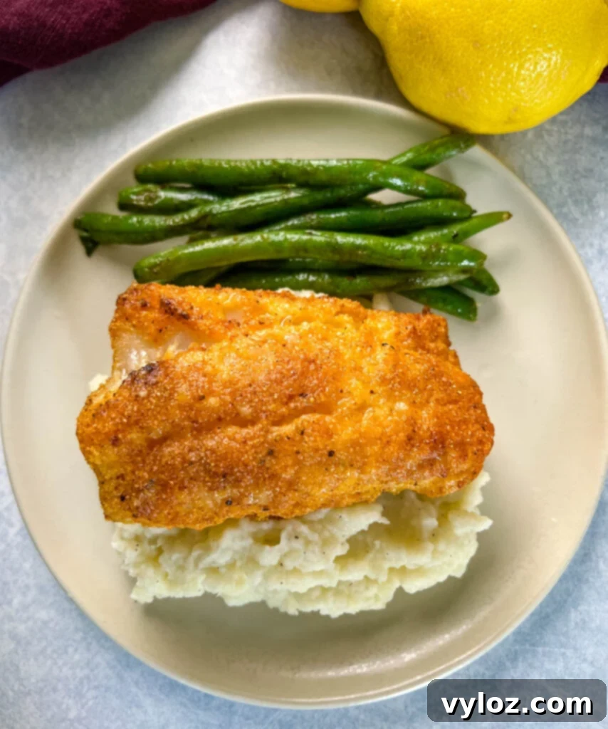 lemon pepper fish, mashed potatoes, and green beans on a plate