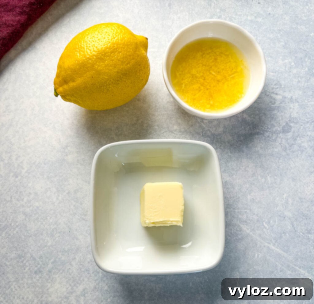 Fresh lemons and a block of unsalted butter in separate bowls, representing the pure and simple ingredients for the homemade lemon butter sauce.