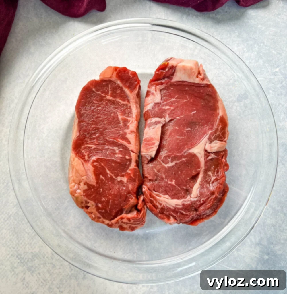 Zesty Lemon Pepper Steak 3 raw steaks in a glass pan