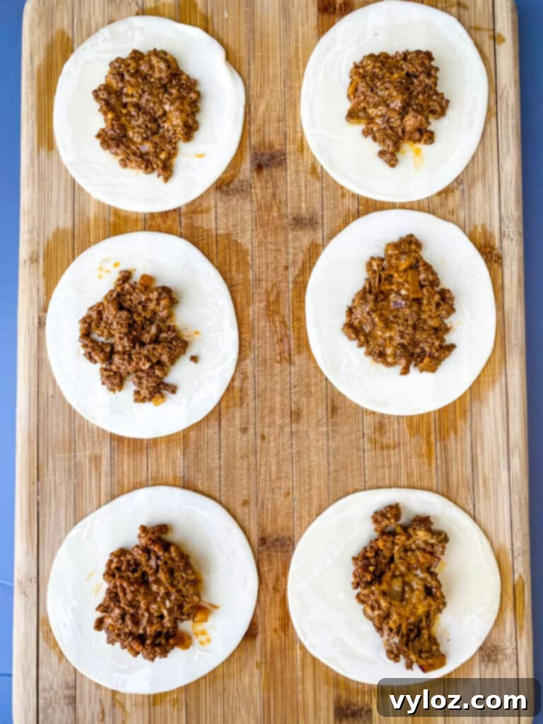 A tray of freshly baked beef and cheese empanadas, golden brown and ready to serve.